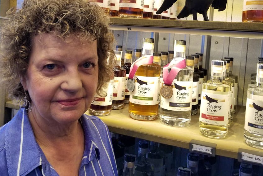 Jill Linquist, president of Raging Crow Distillery in North River is seen displaying gin and vodka products that have received national taste awards.