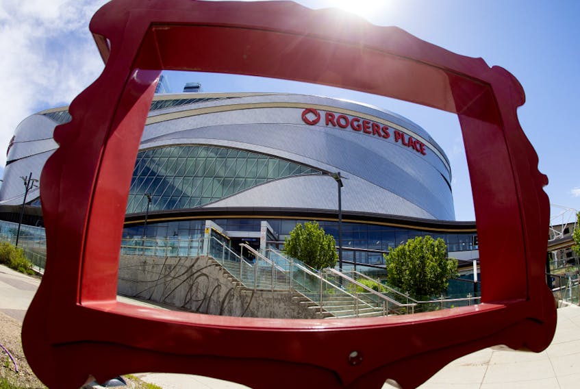 Rogers Place is framed by part of a public sculpture titled Still Life by Studio F-Minus, in Edmonton on Monday June 8, 2020. The ice has been put back in at Roger Place and will be available to members of the Edmonton Oilers for voluntary on-ice sessions.