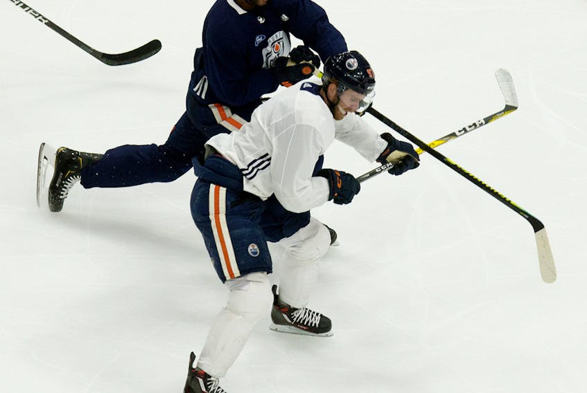 Darnell Nurse (25) battles Connor McDavid (97) during the first day of Edmonton Oilers training camp for the 2019-20 NHL Return to Play initiative at Rogers Place in Edmonton on Monday July 13, 2020.