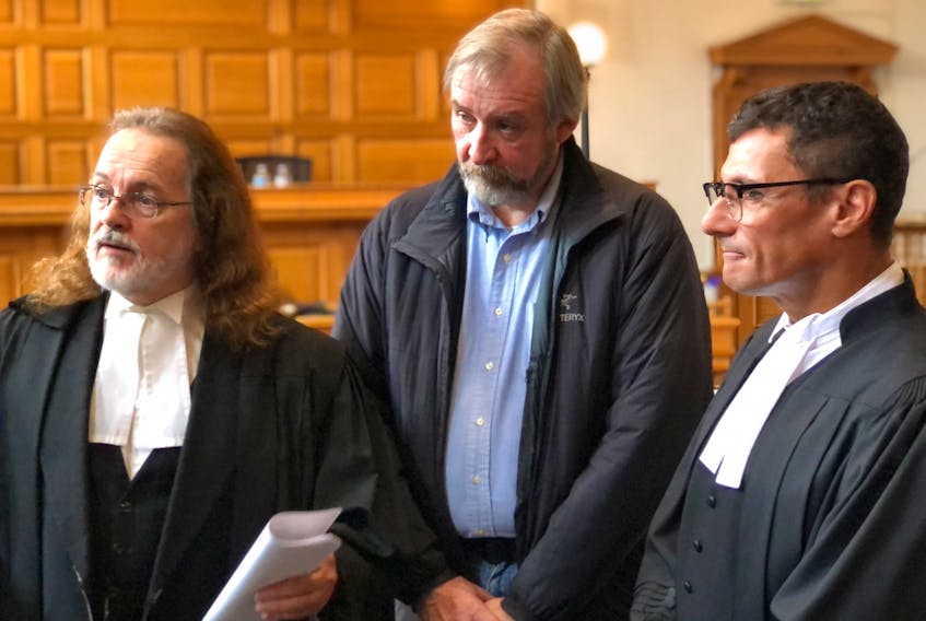 William Parsons (centre) and his lawyers, Bob Buckingham (left) and Eli Baker, speak to members of the media at Newfoundland and Labrador Supreme Court in St. John's Friday morning, after the 20 fraud-related charges Parsons was facing as former vice-president of sales of Hickman Equipment were dismissed.
