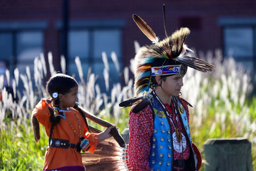 Maya Rae Ford, 4, left, and Linden Redbear Levis, 15, a northern traditional dancer from New Brunswick, are seen before Levis performs before a free salmon dinner, put on behalf of the Mi'kmaq Native Friendship Centre, part of Treaty Day festivities on the waterfront in Halifax Friday October 1, 2021.

TIM KROCHAK PHOTO