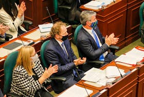 Nova Scotia Premier Tim Houston, right, watches with MLAs Karla MacFarlane, left, and Allan MacMaster as Lt.-Gov. Arthur LeBlanc reads the speech from the throne at Province House in Halifax on Tuesday, Oct. 12, 2021.