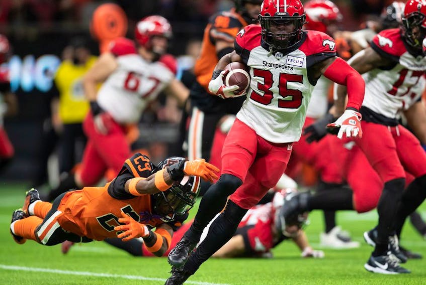  The Calgary Stampeders’ Ka’Deem Carey gets away from BC Lions’ Jalon Edwards-Cooper at BC Place in Vancouver on Saturday, Oct. 16, 2021.