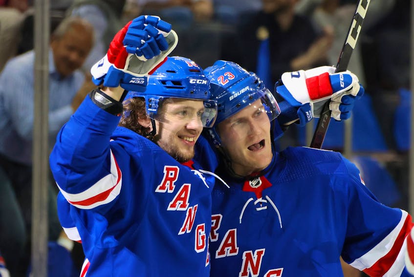 Artemi Panarin #10 of the New York Rangers (L) celebrates a second period goal by Adam Fox #23 (R) against the Dallas Stars at Madison Square Garden on October 14, 2021 in New York City.  