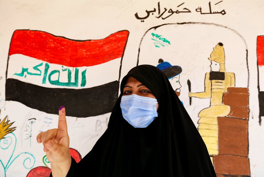 An Iraqi woman shows her ink-stained finger after casting her vote at a polling station during the parliamentary election in Sadr city, Baghdad, Iraq, on Oct. 10. Wissam Al-Okaili / REUTERS