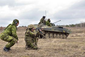 A Canadian Forces instructor provides guidance and safety support to a Ukrainian soldier during section attack practice as part of small team training, at the International Peacekeeping and Security Centre in Starychi, Ukraine, on March 3, 2017. 