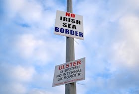 Signs reading “No Irish Sea border” and “Ulster is British, no internal UK Border” are seen affixed to a lamp post at the Port of Larne, Northern Ireland. REUTERS File photo