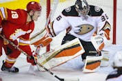  Anaheim Ducks goaltender John Gibson protects the net from the Calgary Flames’ Matthew Tkachuk at the Scotiabank Saddledome in Calgary on Monday, Oct. 18, 2021.