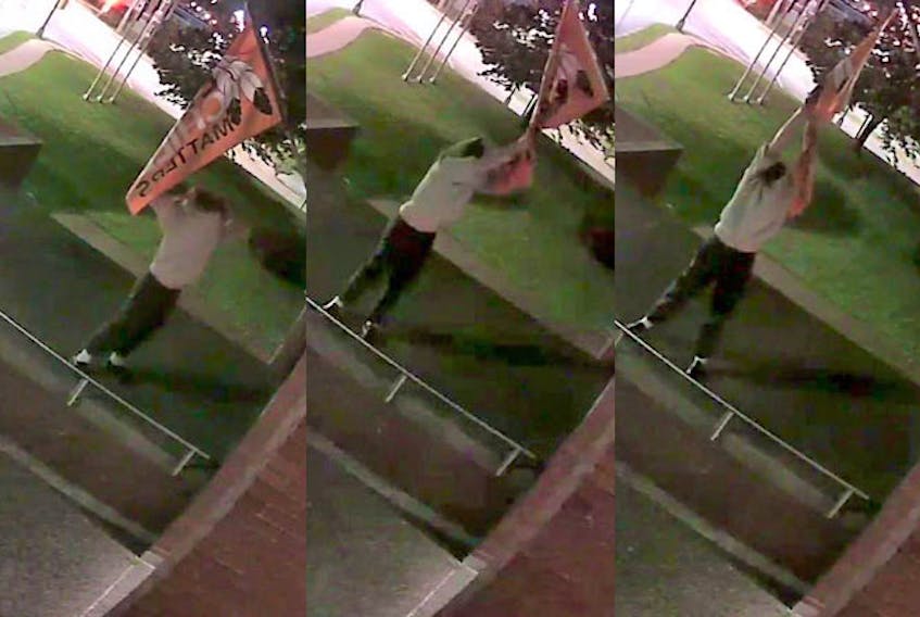In these three images taken from video, a man rips down an Every Child Matters flag from in front of Halifax police headquarters early Saturday morning, Oct. 16, 2021.