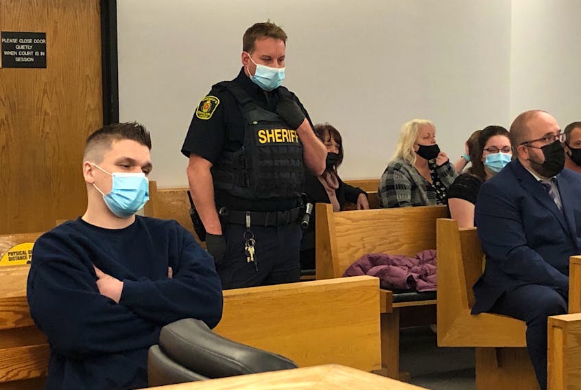 Brandon Noftall (left) sits in a provincial courtroom in St. John's Wednesday, Oct. 20, prior to the start of his preliminary hearing on charges of second-degree murder, assault and court order breaches. Noftall is accused of killing his stepfather, Bobby Noftall, last December. Seated to the right are Bobby Noftall's loved ones.
