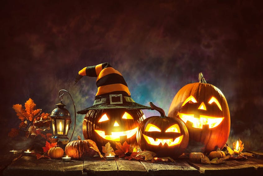  Halloween jack-o’-lanterns with burning candles are pictured in a file photo.