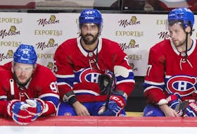 Montreal Canadiens' Jonathan Drouin, Mathieu Perreault and Josh Anderson stay on the bench following the final siren in their loss to the Carolina Hurricanes in Montreal on Oct. 21, 2021. 