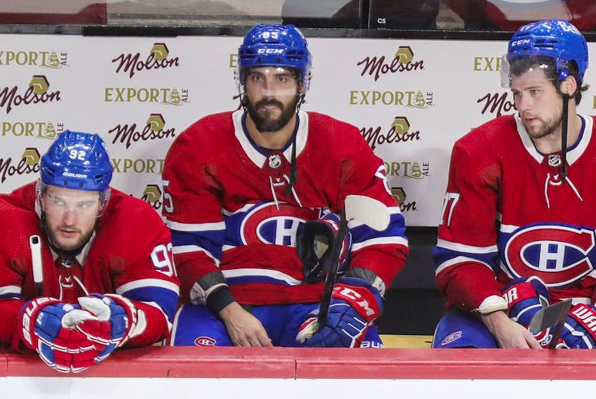 Montreal Canadiens' Jonathan Drouin, Mathieu Perreault and Josh Anderson stay on the bench following the final siren in their loss to the Carolina Hurricanes in Montreal on Oct. 21, 2021. 