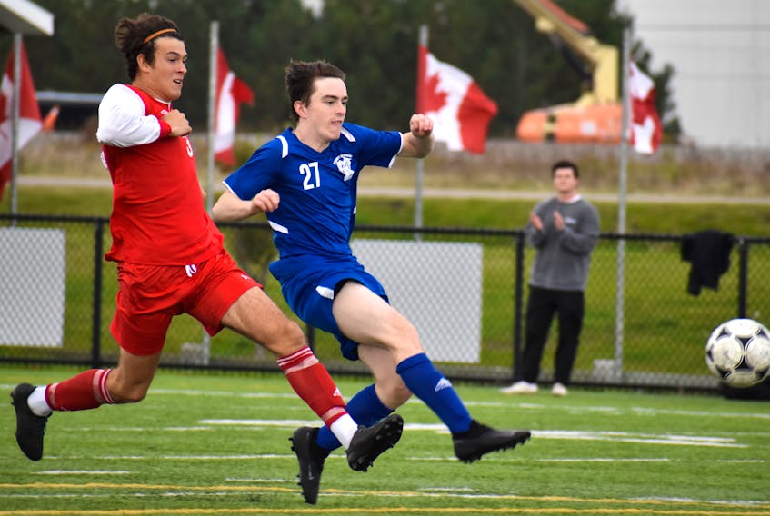 Nolan Brophy of the Sydney Academy Wildcats, right, takes a shot on goal as he's chased by Jack Gogan of the Riverview Ravens during School Sport Nova Scotia Highland Region Division 1 soccer championship action at Open Hearth Park in Sydney, Friday. Sydney Academy won the game 1-0. JEREMY FRASER/CAPE BRETON POST