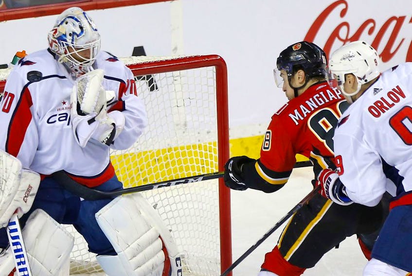 The Calgary Flames’ Andrew Mangiapane battles Washington Capitals goaltender Braden Holtby at the Scotiabank Saddledome in Calgary on Oct. 22, 2019. 