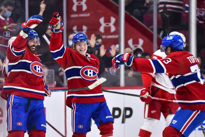 Canadiens' Mathieu Perreault, left, celebrates his third goal of the game with teammates Cole Caufield, centre, and Tyler Toffoli during the third period against the Detroit Red Wings at the Bell Centre on Saturday, Oct. 23, 2021, in Montreal.