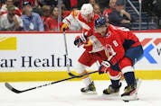  The Washington Capitals’ Alex Ovechkin battles for the puck with the Calgary Flames’ Dillon Dube at Capital One Arena in Washington on Saturday, Oct. 23, 2021,