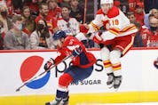  The Calgary Flames’ Matthew Tkachuk avoids the check of the Washington Capitals’ Trevor van Riemsdyk at Capital One Arena in Washington on Saturday, Oct. 23, 2021.