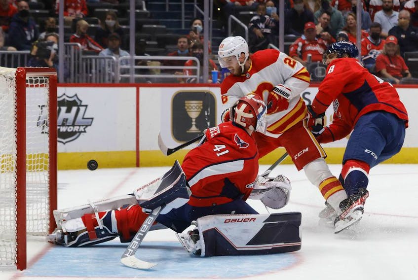 The Calgary Flames’ Elias Lindholm scores a goal on Washington Capitals goaltender Vitek Vanecek at Capital One Arena in Washington on Saturday, Oct. 23, 2021.