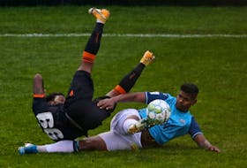 HFX Wanderers' Eriks Santos makes a deft sliding tackle on a sprawling Omar Browne of Forge FC during the second half of their Canadian Premier League match Saturday afternoon at the Wanderers Grounds. - TIM KROCHAK / THE CHRONICLE HERALD
