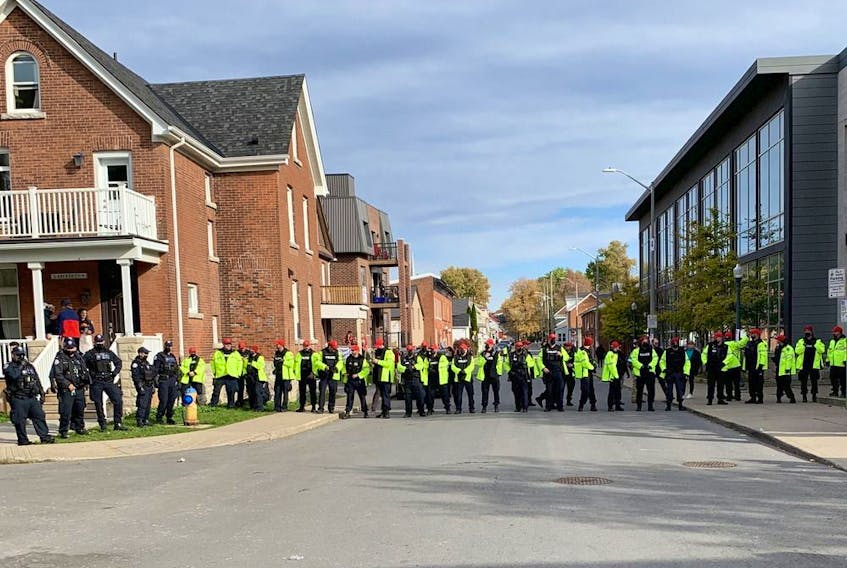  Police officers from Durham region form a blockade at the intersection of Earl and Aberdeen streets in Kingston’s University District on Saturday.