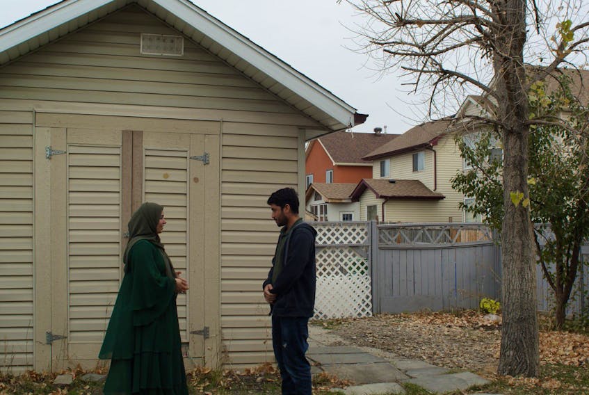 Azatullah and Mastora, both Afghan refugees, arrived in Canada with 11 other relatives in August. They stand in the backyard of their new home in Calgary's north-east. October 13, 2021 (Bryony Lau photo)