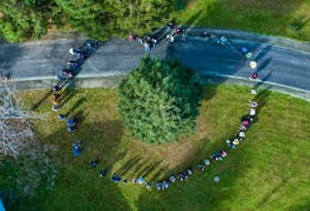 Members of L'Arche Cape Breton form a heart shape around the tree set to be donated as part of Nova Scotia's Tree for Boston tradition.