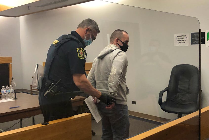 A sheriff handcuffs Bobby Newell and escorts him from a provincial courtroom in St. John's Wednesday morning, Oct. 27. 