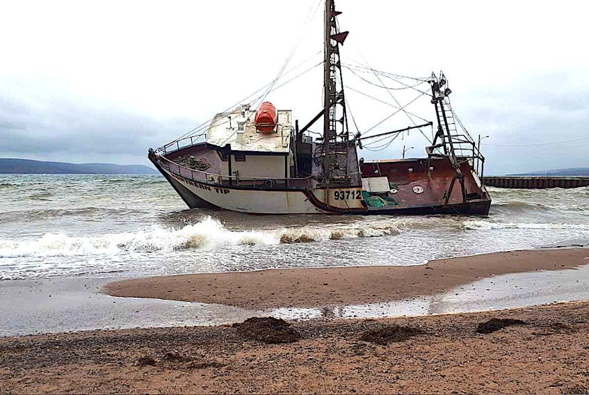 The fishing vessel Northern Tip on its side aground in Iona late afternoon Wednesday, after breaking from the wharf earlier in the day. The Canadian Coast Guard is on site and working with the owner on a recovery plan. Contributed/Jim MacNeil