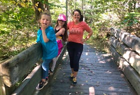 Heather Fegan and her daughters, Rosie and Anna take a rest to admire the woodland scenery in Belchers Marsh Trail in Clayton Park West, N.S. 