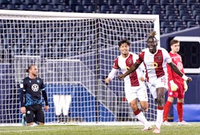 Valour FC's William Akio celebrates his first-half goal while a dejected Peter Schaale and Kieran Baskett of the HFX Wanderers look on during a Canadian Premier League match Tuesday in Winnipeg. - CANADIAN PREMIER LEAGUE 