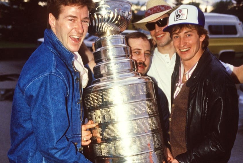 Edmonton Oilers Kevin Lowe, left, equipment manager Lyle 'Sparky' Kulchisky, Mark Messier and Wayne Gretzky hold the Stanley Cup after leaving David's Restaurant in Edmonton on May 21, 1984.