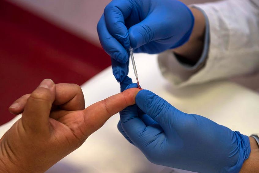  A person undergoes a finger prick blood sample as part of of an antibody rapid serological test for COVID-19 on May 6, 2020 at the Tor Vergata Covid hospital in Rome. (Photo by Tiziana FABI/AFP)