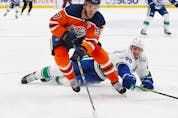 Oilers forward Connor McDavid carries the puck around Vancouver Canucks defenceman Oliver Ekman-Larsson at Rogers Place in Edmonton on Oct. 13.