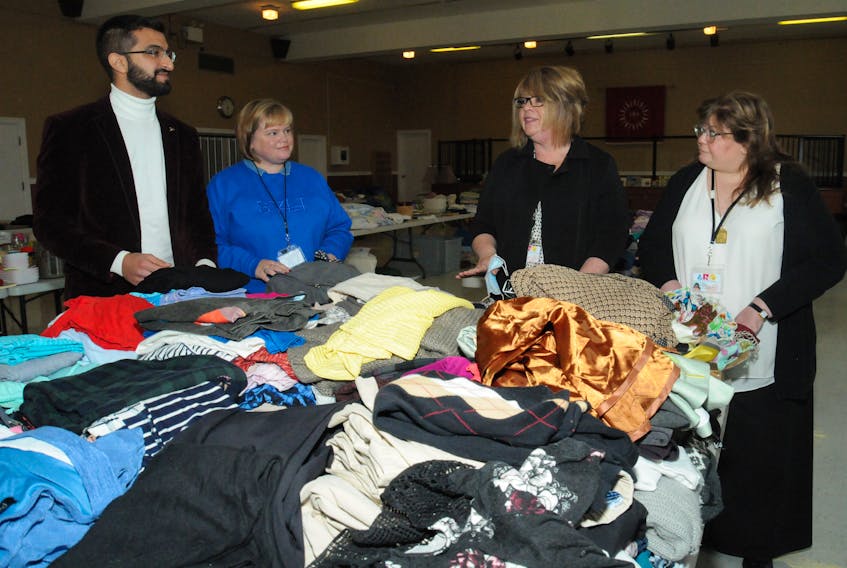 Officials with the Association for New Canadians (ANC) in St. John’s met with reporters at the St. Pius X Parish Hall on Smithville Crescent in St. John’s on Thursday morning, Oct. 28, to provide an update on the Afghanistan refugees who arrived in St. John’s on Tuesday night. As well, displayed were some of the many items donated thus far for them by local citizens. They ANC is welcoming additional donations to support the refugees. Pictured (from left) admiring some of the clothing donations are ANC staff members Antwone Aslan, settlement co-ordinator; Alice Keough, community connections co-ordinator; Megan Morris, executive director; and Suzy Haghighi, director of settlement services.
-Joe Gibbons/The Telegram
