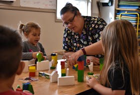 Kellie Davies, vice-president of operations for Milestones Early Learning Centre in Stratford, plays with some of the children at the centre on Sept. 28. The children, from left, are Thatcher, Maria and Sadie. The centre did not disclose the children's last names.