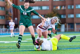 Abby MacNeil of the Cape Breton Capers, left, tries to chip the ball over Saint Mary's Huskies goalkeeper Grace Morrison during Atlantic University Sport action at Huskies Stadium on Friday. Cape Breton won the game 4-1. PHOTO CONTRIBUTED/SAINT MARY'S HUSKIES.