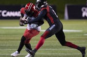 Ottawa Redblacks defensive back Randall Evans tackles Calgary Stampeders wide receiver Hergy Mayala as he runs with the ball at TD Place Stadium in Ottawa on Friday, Oct. 29, 2021.