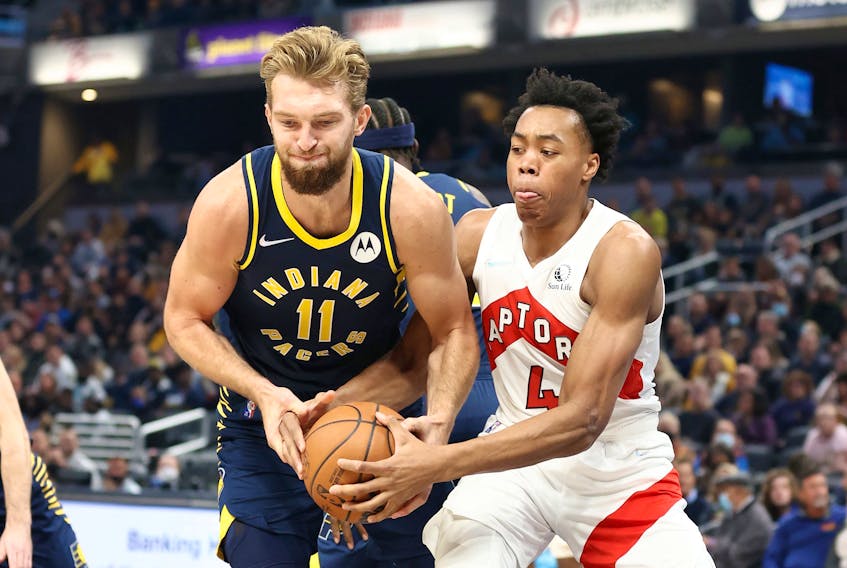 Domantas Sabonis #11 of the Indiana Pacers and Scottie Barnes #4 of the Toronto Raptors battle for a loose ball during the game at Gainbridge Fieldhouse on October 30, 2021 in Indianapolis, Indiana.  