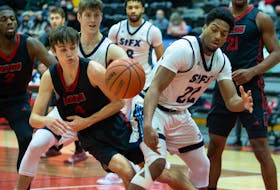 Michael Utsalo of the St. Francis Xavuer X-Men and Rees Hasson of the UNB Reds battle for the ball during AUS men's basketball action Saturday in Fredericton. - JAMES WEST / UNB ATHLETICS