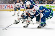  Vancouver Canucks’ Quinn Hughes (right) tries to check Edmonton Oilers’ Derek Ryan during first period NHL hockey action in Vancouver on Saturday, Oct. 30, 2021.