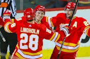  The Calgary Flames’ Matthew Tkachuk (centre) celebrates with Elias Lindholm and Sean Monahan after scoring against the Philadelphia Flyers at the Scotiabank Saddledome in Calgary on Saturday, Oct. 30, 2021.