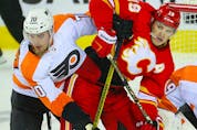  The Philadelphia Flyers’ Rasmus Ristolainen battles the Calgary Flames’ Matthew Tkachuk at the Scotiabank Saddledome in Calgary on Saturday, Oct. 30, 2021.
