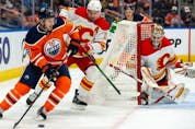  The Edmonton Oilers’ Zach Hyman battles the Calgary Flames’ Mikael Backlund during preseason action at Rogers Place in Edmonton on Monday, Oct. 4, 2021.