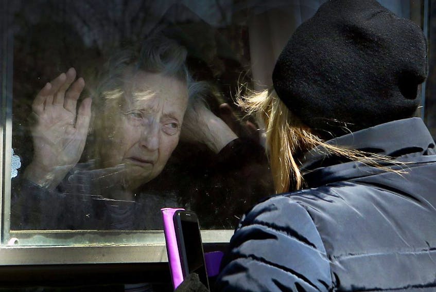 Diane Colangelo visits her 86-year-old mother Patricia through a window at Orchard Villa long-term care home in Pickering on April 22, 2020.