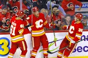  The Calgary Flames’ Michael Stone (centre) celebrates after scoring a preseason goal against the Seattle Kraken at the Saddledome in Calgary on Wednesday, Sept. 29, 2021.