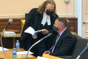 George Pottle (seated), a lieutenant with the St. John's Regional Fire Department, speaks with his defence lawyer, Bob Buckingham, during a break in his trial at Newfoundland and Labrador Supreme Court in St. John's Tuesday morning, Oct. 5. Pottle has pleaded not guilty to assaulting and threatening a woman in April 2018.