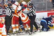  The Winnipeg Jets attempt to get at Calgary Flames forward Blake Coleman after his hit on Jansen Harkins (right) at Canada Life Centre in Winnipeg on Wednesday, Oct. 6, 2021.