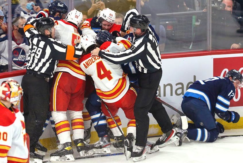  The Winnipeg Jets attempt to get at Calgary Flames forward Blake Coleman after his hit on Jansen Harkins (right) at Canada Life Centre in Winnipeg on Wednesday, Oct. 6, 2021.
