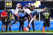 Los Angeles Chargers wide receiver Josh Palmer (5) makes a catch for a touchdown while defended by New England Patriots strong safety Adrian Phillips (21) and cornerback Jalen Mills (2) during the second half at SoFi Stadium. (Orlando Ramirez-USA TODAY Sports)
